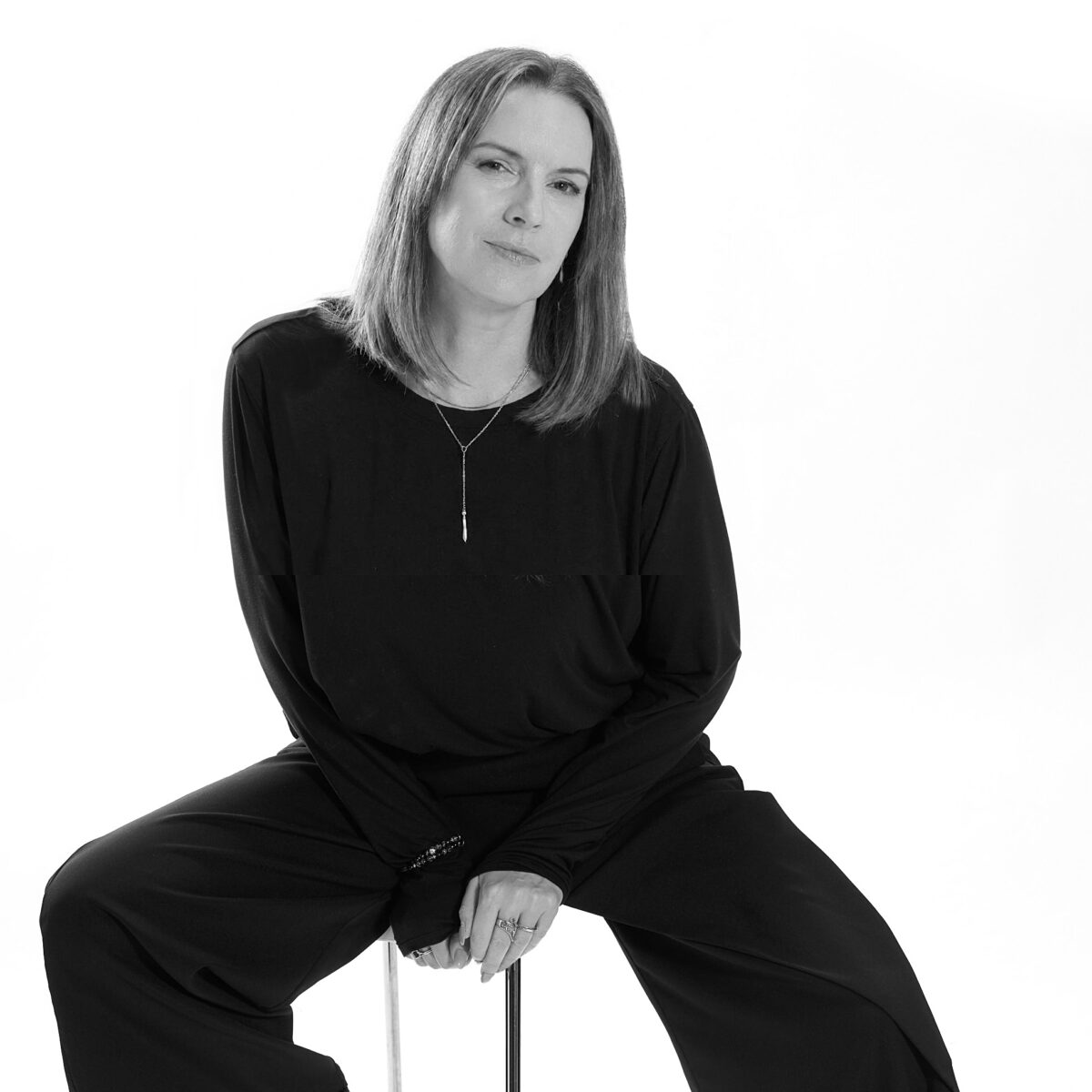 Portrait en noir et blanc de Marie-Hélène Pierre, assise et vêtue de noir.